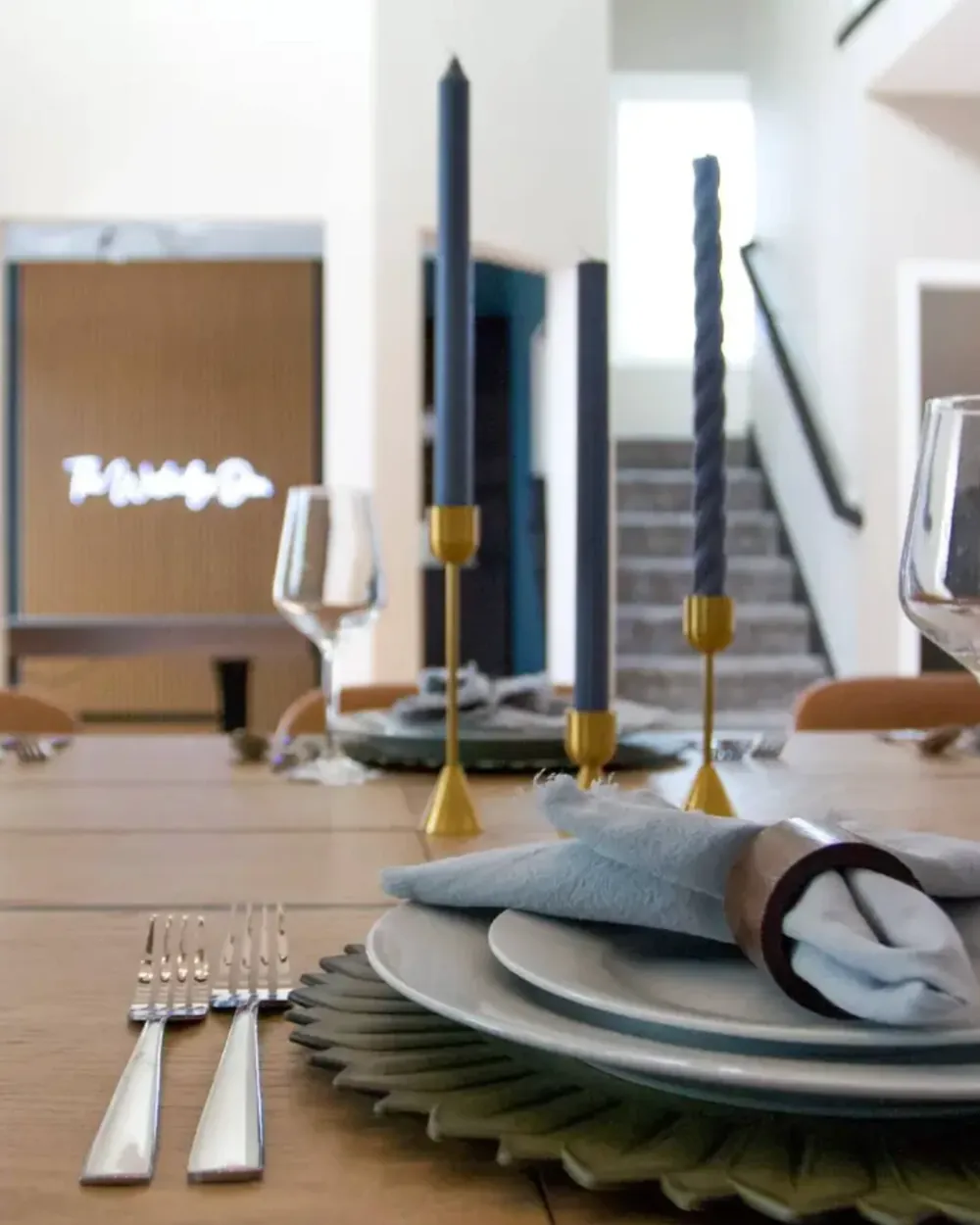 A table set for dinner at The Westridge Den, with the neon sign glowing behind it