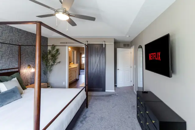 Stylish barn door leads you from the spacious primary suite through to the en-suite bathroom.